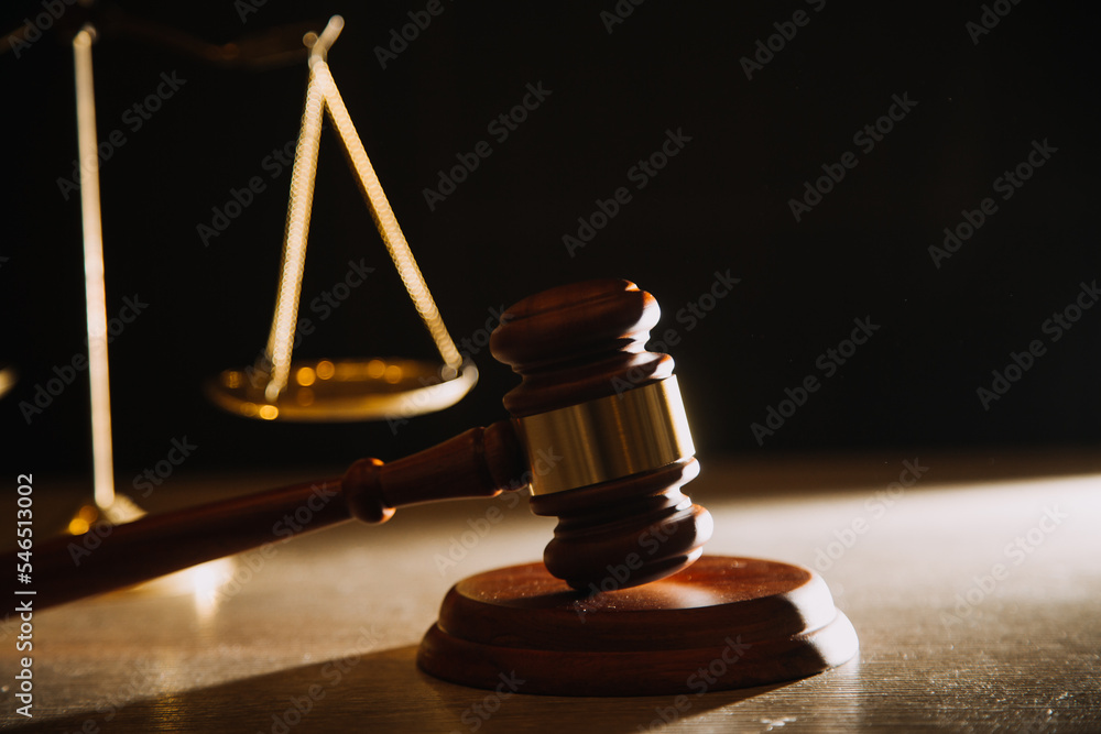 Business and lawyers discussing contract papers with brass scale on desk in office. Law, legal services, advice, justice and law concept picture with film grain effect Business and lawyers discussing contract papers with brass scale on desk in office. Law, legal services, advice, justice and law concept picture with film grain effect