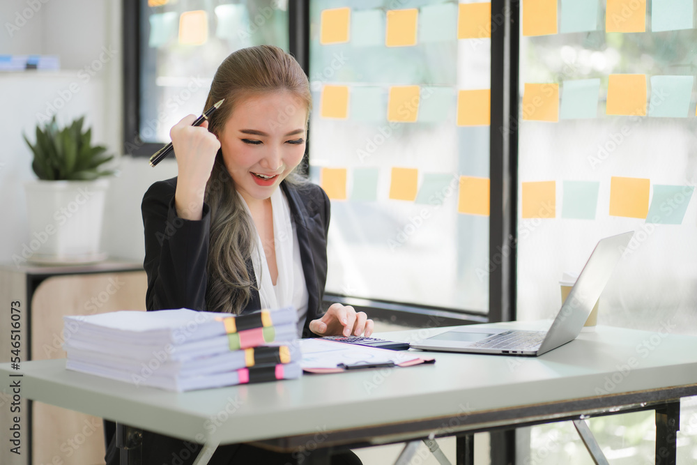 business woman or accountant who are using a calculator to calculate business data Accounting documents and laptop computer at the office business idea