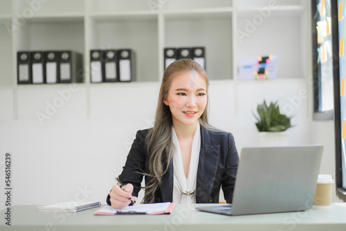 business woman or accountant who are using a calculator to calculate business data Accounting documents and laptop computer at the office business idea