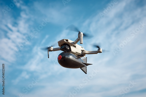 consumer civilian drone with a big bomb on board flies in the blue sky