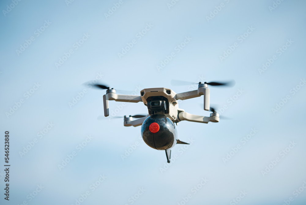 consumer civilian drone with a big bomb on board flies in the blue sky  Photos | Adobe Stock