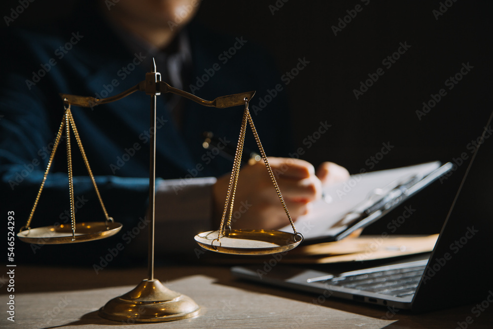 Business and lawyers discussing contract papers with brass scale on desk in office. Law, legal services, advice, justice and law concept picture with film grain effect Business and lawyers discussing contract papers with brass scale on desk in office. Law, legal services, advice, justice and law concept picture with film grain effect