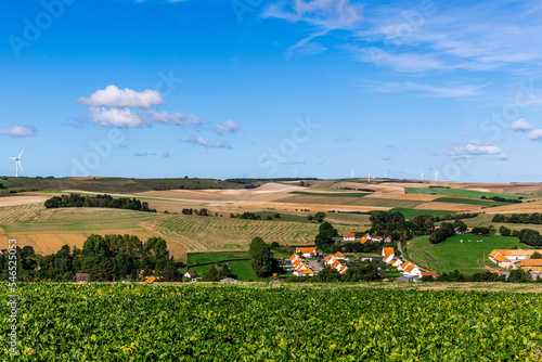 Village dans un paysage de campagne avec ciel bleu et nuages