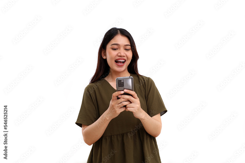 Excited beautiful young asian woman standing while holding cellular phone. Good news concept. Isolated with copyspace Excited beautiful young asian woman standing while holding cellular phone. Good news concept. Isolated with copyspace
