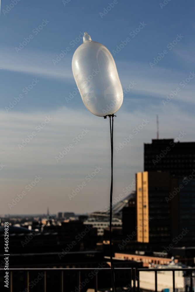 Naklejka premium Vertical shot of an inflated floating condom in the sky in Berlin