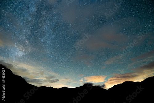 Stars and Milky way visible above mountains in alps, Sauris Italy