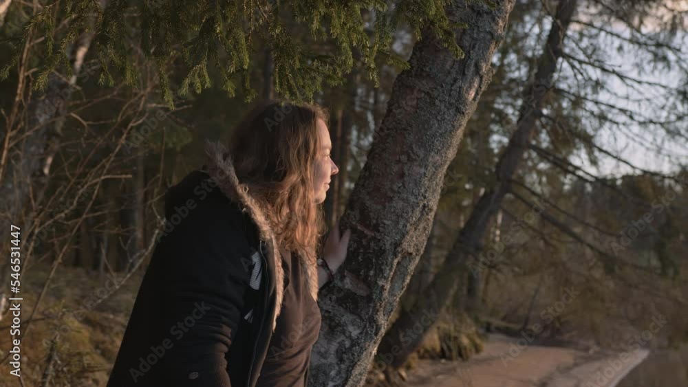 A young, plump beautiful girl at sunset by the lake in the rays of the sun A young, plump beautiful girl at sunset by the lake in the rays of the sun