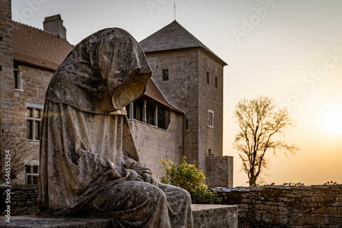 Beautiful shot of a hooded stone statue in the Chateau de Gevrey Chambertin, in Burgundy, France photo