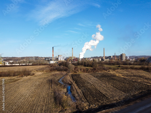Factory chimney blowing pollution in environment. Industrial air pollution from smokestacks, aerial drone view.