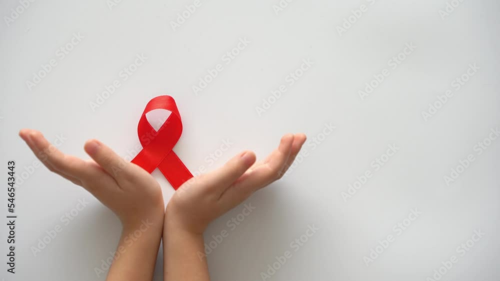 AID red ribbon in child hands on white background, symbol of struggle ...