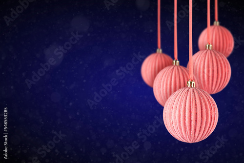 Pink Christmas tree velvet ornaments hanging with copy space. Christmas Balls made of glass or plastic hanging over abstract dark blue background. photo