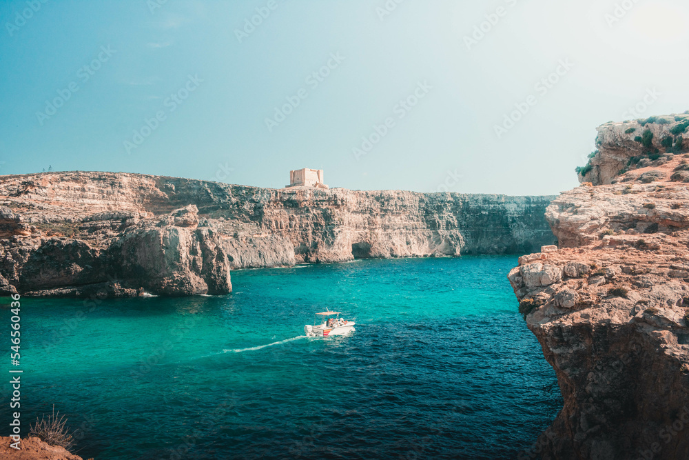 small boat in a cyan lake of an island of malta