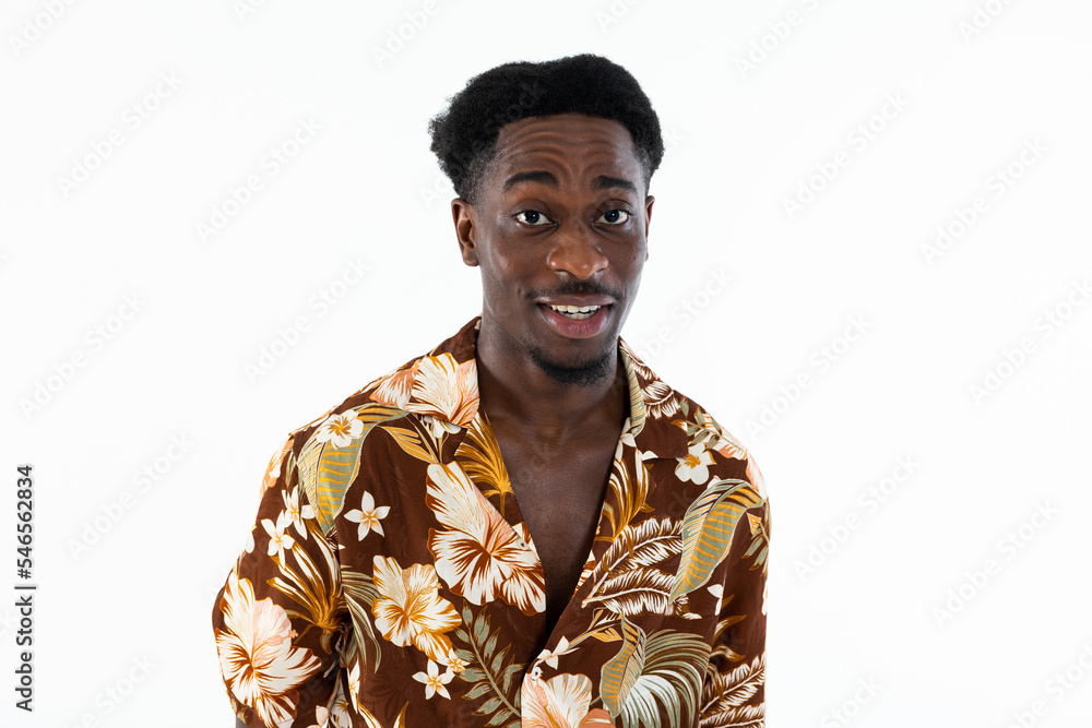 Curious african american man looking at camera surprised talking wearing colorful shirt standing n white background isolated in studio. Curious african american man looking at camera surprised talking wearing colorful shirt standing n white background isolated in studio.