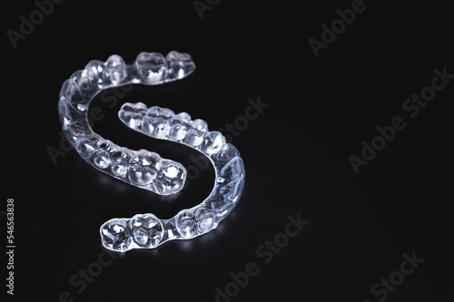 pair of transparent braces lies on a black background. orthodontics, bite correction and cometic dental care