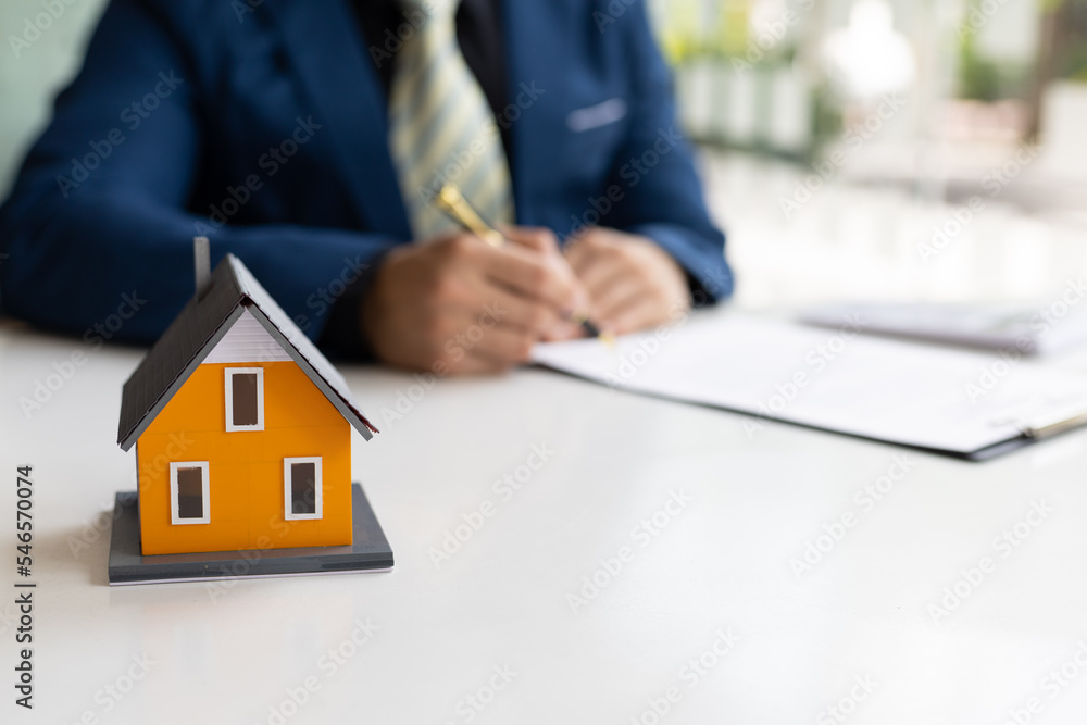 Businessman or real estate agent signs a contract to sell the house legally. Real estate consultant, legal agreement contract, rental, lease, mortgage. Businessman or real estate agent signs a contract to sell the house legally. Real estate consultant, legal agreement contract, rental, lease, mortgage.