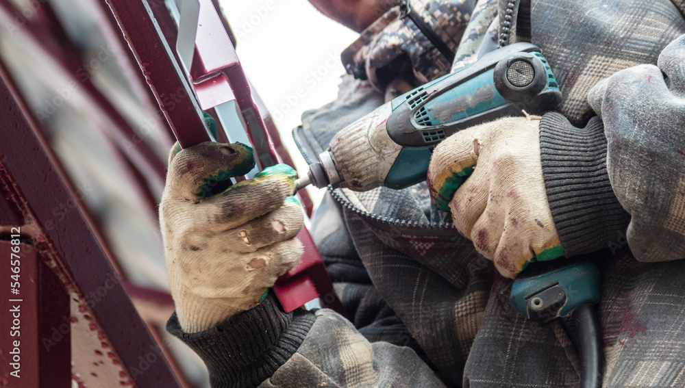 The worker sets the metal sheets on the weight. The worker sets the metal sheets on the weight.