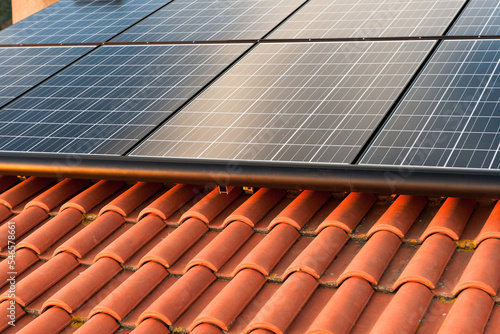 Solar panels are mounted on a red Italian tile roof to produce solar energy.