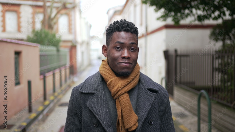 Confident black man walking in city during winter season, person walks forward looking at camera Confident black man walking in city during winter season, person walks forward looking at camera