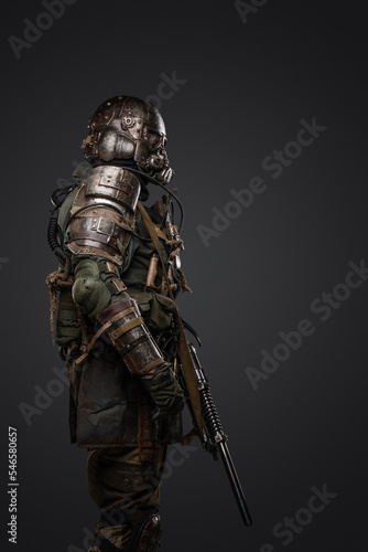 Tela Shot of post apocalyptic soldier dressed in armour and gas mask holding shotgun