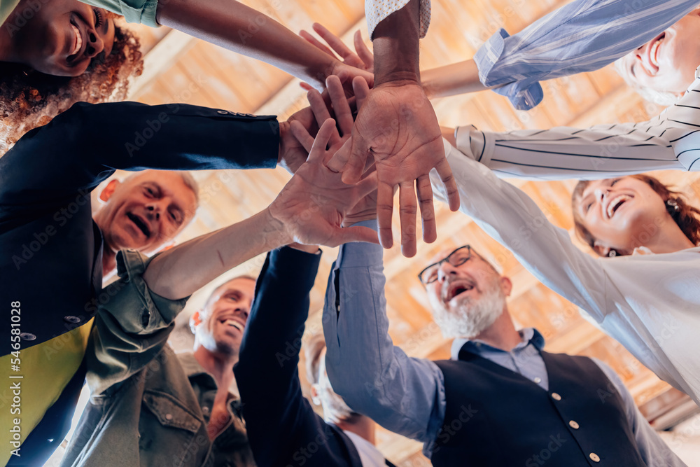 Fototapeta premium team of diverse people in it as one - group of businesspeople joining their hands in solidarity - stacking hands concept - stock photo