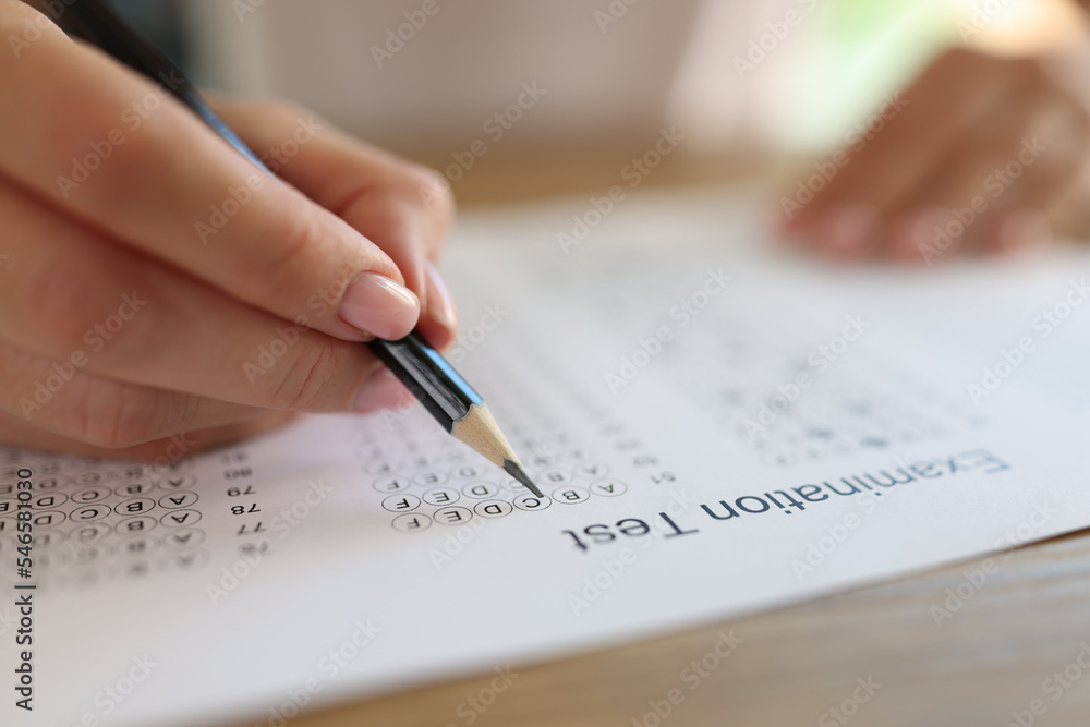 Hand with pencil on examination test paper close up. Hand with pencil on examination test paper close up.