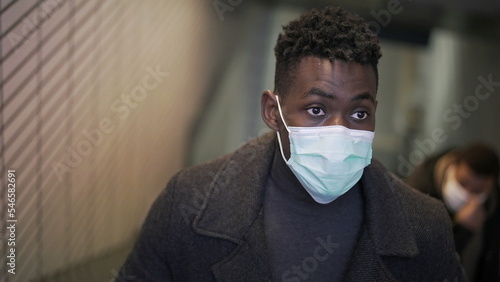 Black man wearing covid-19 face mask while commuting underground