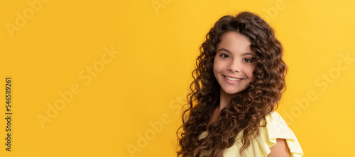 happy kid with long curly hair and perfect skin, beauty. Child face, horizontal poster, teenager girl isolated portrait, banner with copy space.