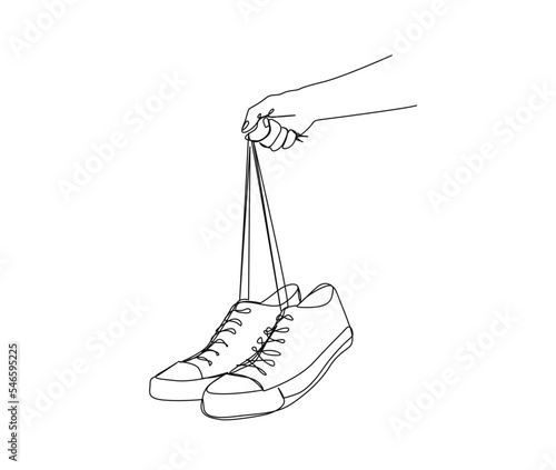 Continuous one line drawing of hand holding sneakers. Fashionable and casual sneakers line art drawing vector design. Hand holds shoes lineart design.