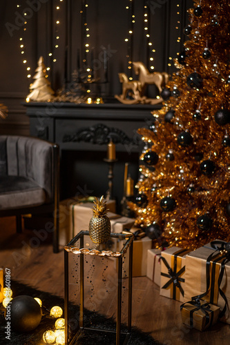 Merry Christmas and Happy Holidays!Beautiful black modern living room decorated for Christmas.Chrystmas Luxury black style living room interior with sofa decorated chic , golden style.Selective focus.