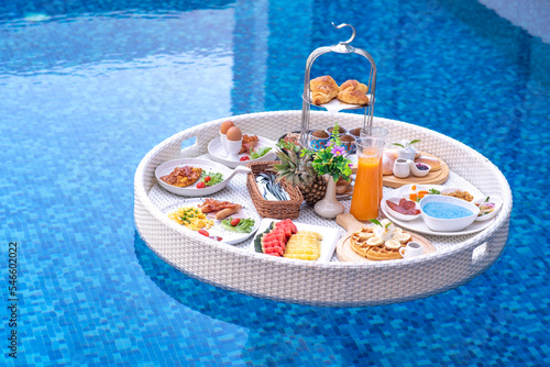 Breakfast in swimming pool, floating breakfast in villa resort. relaxing in calm pool water, healthy breakfast and tropical fruit. photo