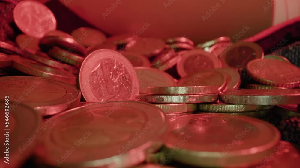 Motion over scattered golden euro coins on fabric sheet at gentle red light in spacious studio extreme close view zoom in Motion over scattered golden euro coins on fabric sheet at gentle red light in spacious studio extreme close view zoom in