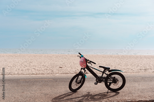 Bicycle with helmet parked on the seaside with sea beach beautiful background.