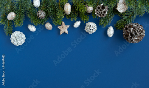 Christmas blue background with fir tree, cones and Christmas decoration. Top view, copyspace. photo