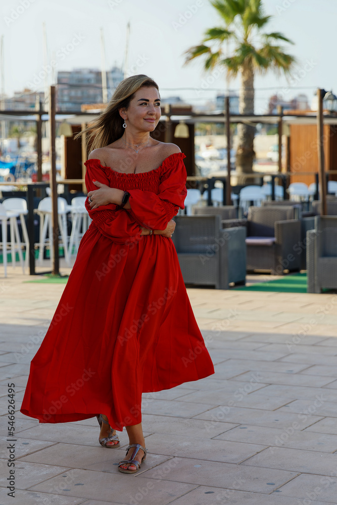 Stylish beautiful woman in a red dress in a cafe Stylish beautiful woman in a red dress in a cafe