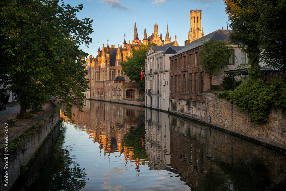 Fototapeta premium Bruges: view in Groenerei, a beautiful stretch of canal passing under three lovely stone bridges, Vismarkt, the monument of Frank Van Acker's bust.