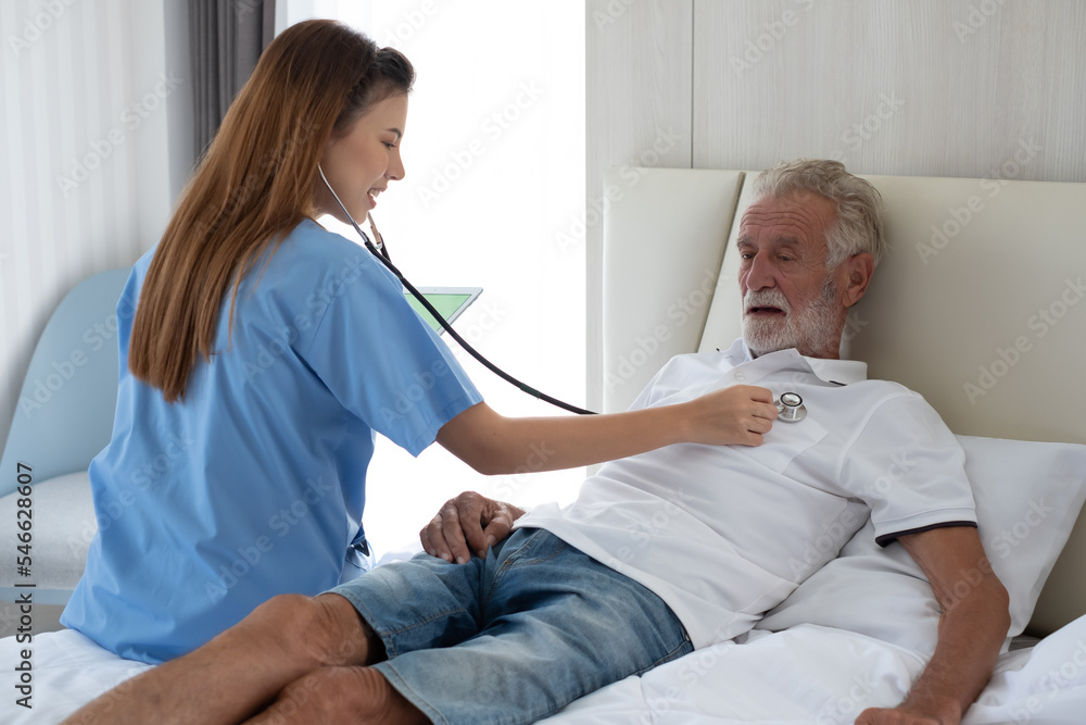 Caring nurse with senior man sitting in the bedroom . caucasian man. Discussing. Caring caregiver and senior citizen. Nurse helping senior patient . Young nurse helping elderly man Caring nurse with senior man sitting in the bedroom . caucasian man. Discussing. Caring caregiver and senior citizen. Nurse helping senior patient . Young nurse helping elderly man