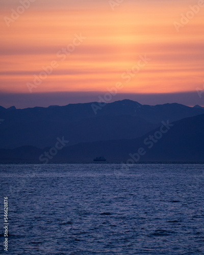 Ferry in norwegian fjord during sunset