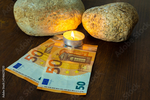 Euro paper bills with a burning candle
