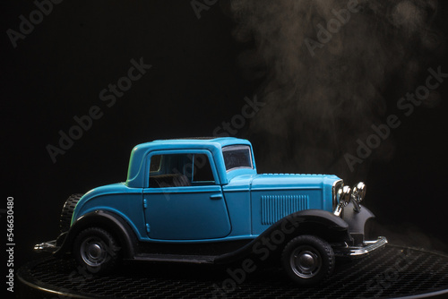 Retro car on a black background. Smoke is coming from the hood of the car. Broken car with steam from the engine.