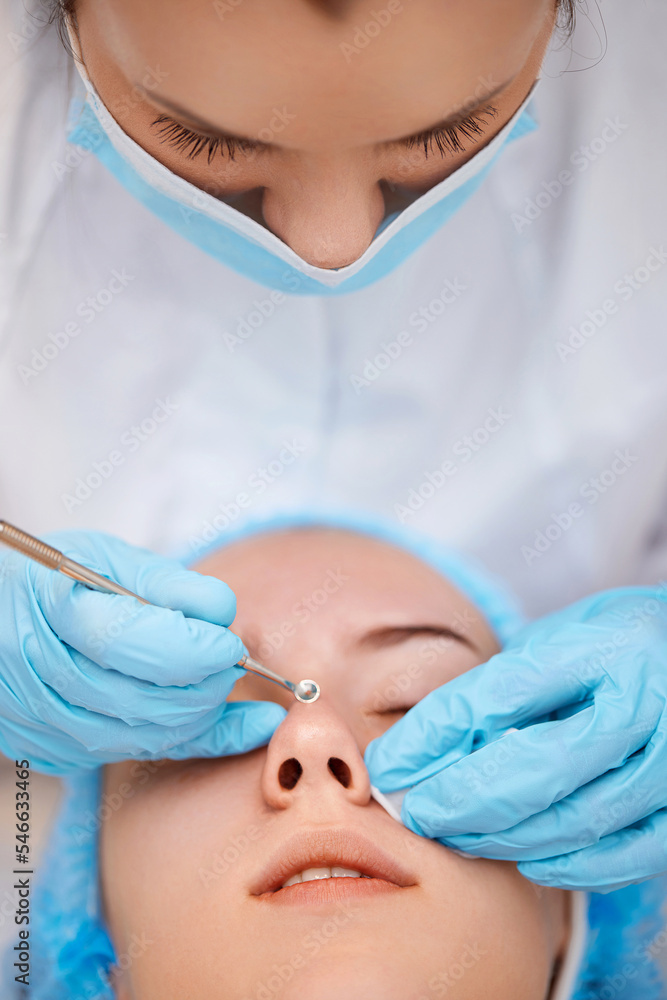 Naklejka premium woman during a mechanical face cleansing procedure