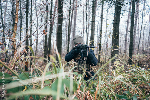 An armed soldier patrols the forest