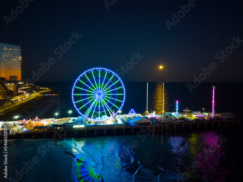 Night scene of Ferris Wheel on Steel Pier next to Boardwalk in Atlantic City, New Jersey NJ, USA. 