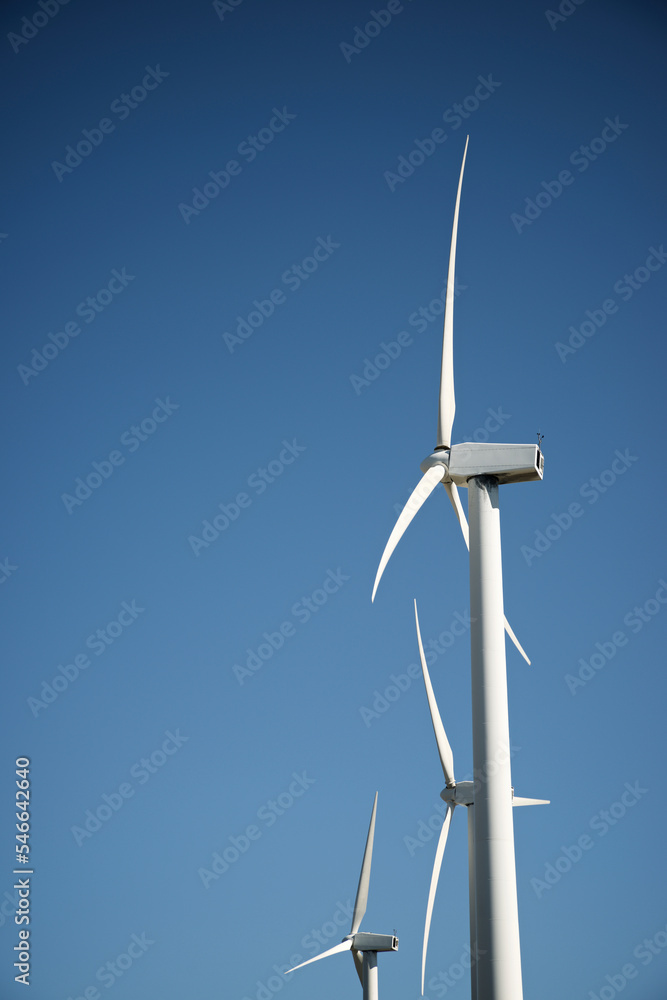 Low angle view of windmills against clear blue sky Low angle view of windmills against clear blue sky