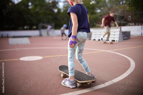 girl and skateboard at skatepark getting ready to ride board