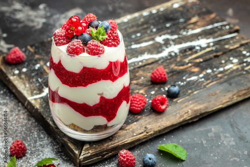 Cranachan raspberry dessert in jar on a dark background. Long banner format photo