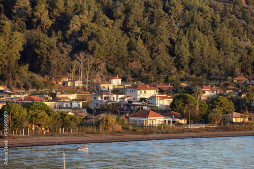 Residential Homes by the beach on Ionian Sea in a small touristic Town. Katakolo, Greece. Sunny Sunrise Sky.
