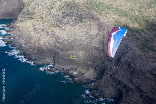 Man flying a paraglider near sea cliffs. photo