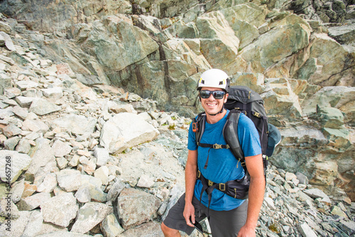 Portrait of mountaineer wearing helmet and backpack. photo