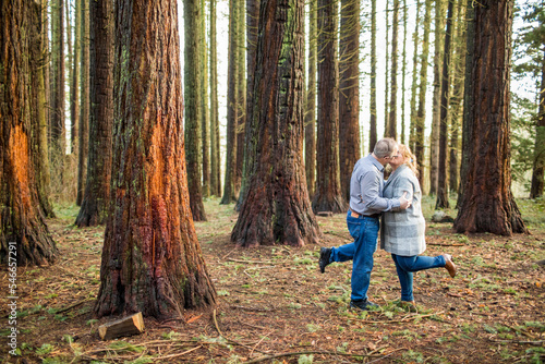 Romantic retired couple kissing in the woods. photo