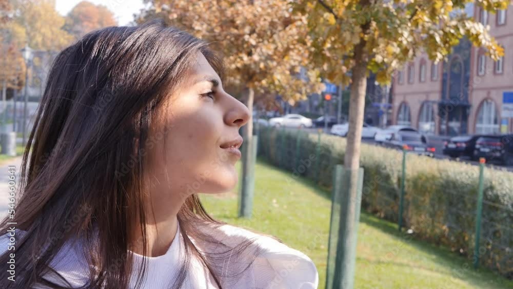 portrait: black-haired middle eastern beauty in the park on a sunny day in autumn looks at the sun and looks away. Cute and lovely young woman enjoying life outdoors portrait: black-haired middle eastern beauty in the park on a sunny day in autumn looks at the sun and looks away. Cute and lovely young woman enjoying life outdoors